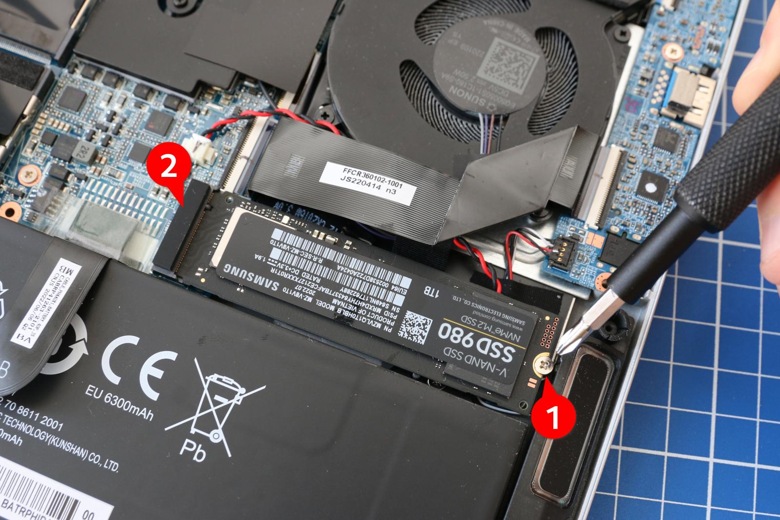 Für den Ausbau des SSD-Moduls drehen Sie die Sicherungsschraube heraus und kippen dann die Platine nach oben aus dem Sockel.